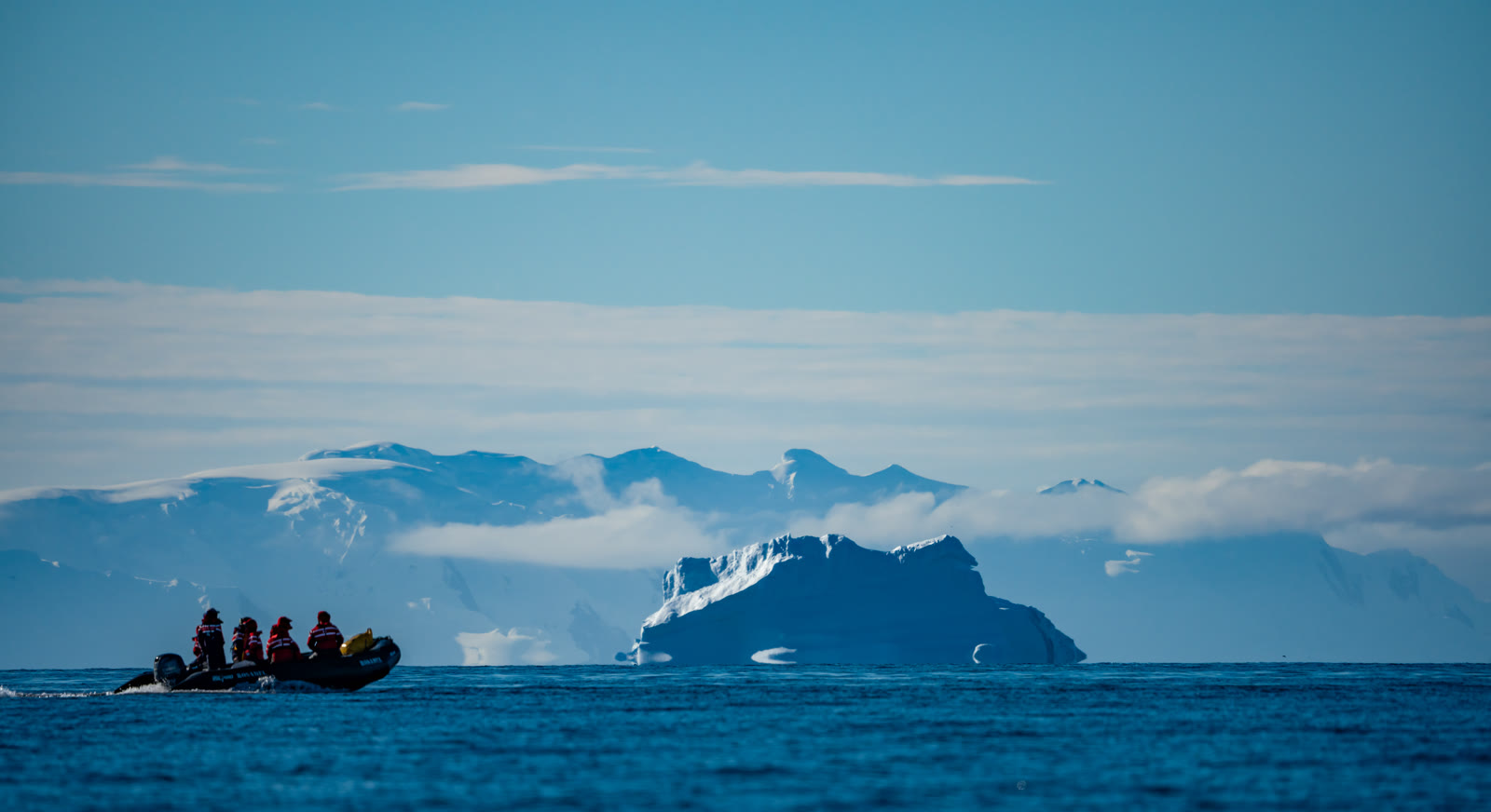 A zodiac cruising past icebergs in Antarctica